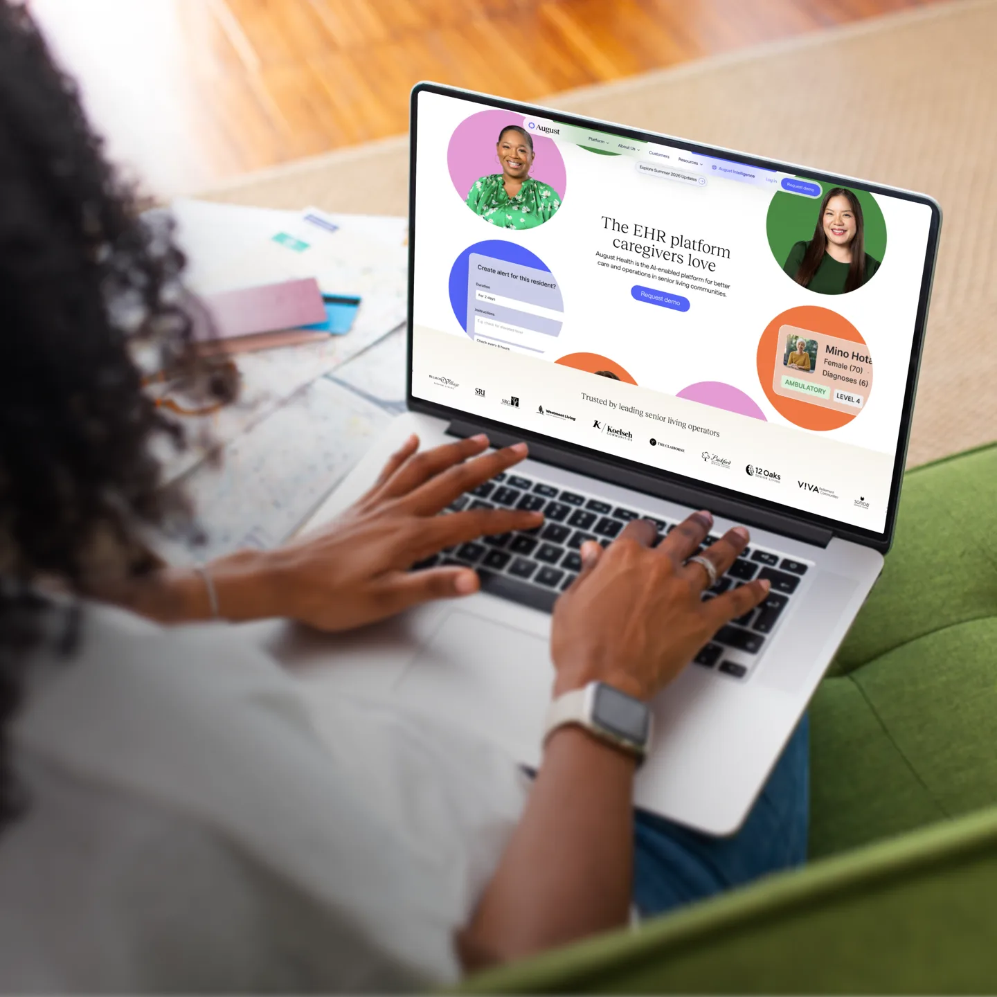 The August Health homepage open on a laptop, seen over the shoulder of someone reading it on a sofa